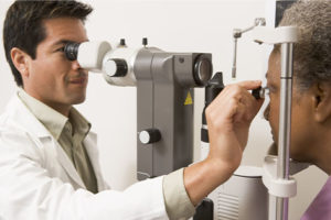 Opthamologist performing a comprehensive eye and vision exam on a new patient.